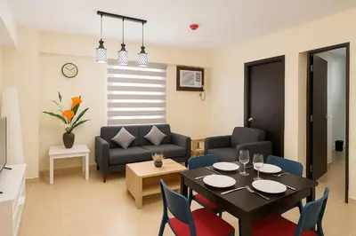 a dining room and living room with a table and chairs at Kasara Urban Resort & Residences in Manila