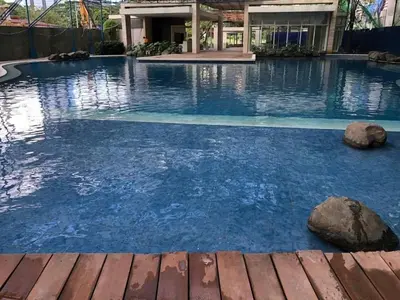 a swimming pool with blue water in a building at Kasara Urban Resort & Residences in Manila