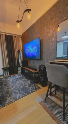 a living room with a flat screen tv on a wall at SW Staycation Sam Suite SMDC Hope Residences Beside SM City in Trece Martires