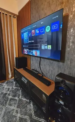 a flat screen tv on a wall with a table at SW Staycation Sam Suite SMDC Hope Residences Beside SM City in Trece Martires