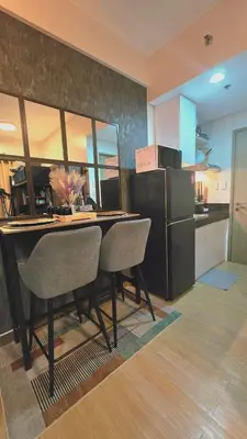 a kitchen with a table with chairs and a refrigerator at SW Staycation Sam Suite SMDC Hope Residences Beside SM City in Trece Martires