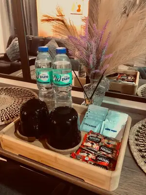 a tray with two bottles of water and some snacks at SW Staycation Sam Suite SMDC Hope Residences Beside SM City in Trece Martires