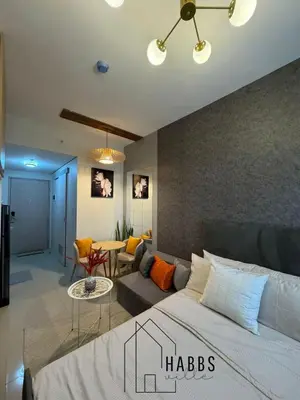 a bedroom with a bed and a living room at HabbsVille at Green 2 Residences by SMDC Dasmarinas Cavite in Dasmariñas