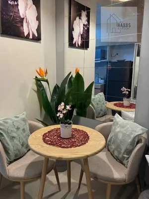 a room with two chairs and a table with flowers on it at HabbsVille at Green 2 Residences by SMDC Dasmarinas Cavite in Dasmariñas