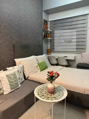 a living room with a bed and a table with a couch at HabbsVille at Green 2 Residences by SMDC Dasmarinas Cavite in Dasmariñas