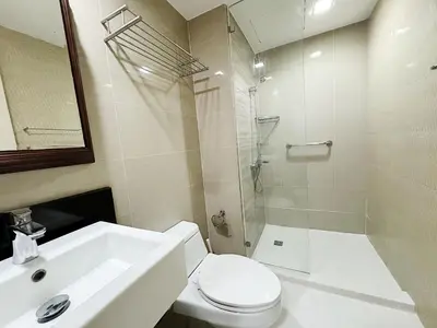 a bathroom with a sink and a toilet and a shower at COZI Venice Luxury Residences Alessandro BGC w Pool Gym in Manila