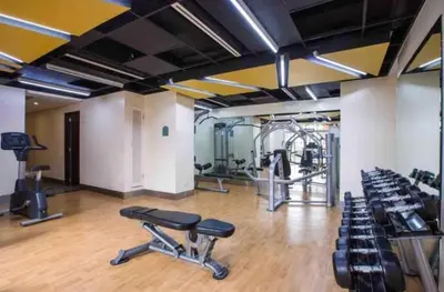 a gym with treadmills and chairs in a room at Condo Hotel type luxury Big Studio in Mckinley Hill taguig in Manila