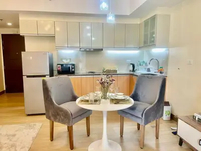 a kitchen with a table and two chairs and a refrigerator at Condo Hotel type luxury Big Studio in Mckinley Hill taguig in Manila