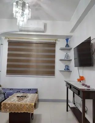a living room with a window with a television and a table at 1BR Condotel - Forbes Town Road near St Lukes BGC Taguig in Manila