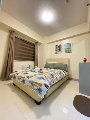 a bedroom with a bed and a window at 1BR Condotel - Forbes Town Road near St Lukes BGC Taguig in Manila