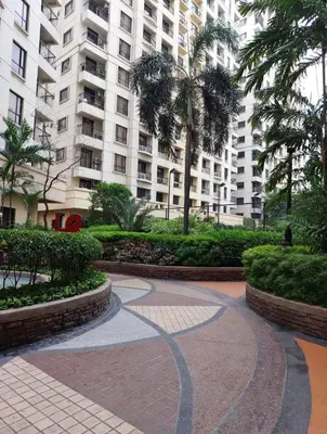 a walkway in front of a large apartment building at 1BR Condotel - Forbes Town Road near St Lukes BGC Taguig in Manila