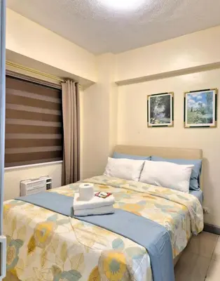 a bedroom with a bed with a tray on it at 1BR Condotel - Forbes Town Road near St Lukes BGC Taguig in Manila