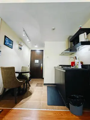 a kitchen with a counter and a table with chairs at Cozy Private Hotel Suite with Bath Tub and Free Pool Access in Manila
