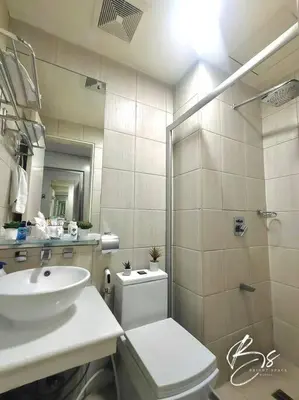 a bathroom with a sink and a toilet and a shower at Birch Tower by Bright Space Manila in Manila