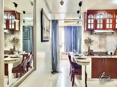 a kitchen with a table and chairs in a room at Birch Tower by Bright Space Manila in Manila