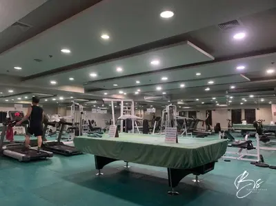 a man walking in a gym with a table in a room at Birch Tower by Bright Space Manila in Manila