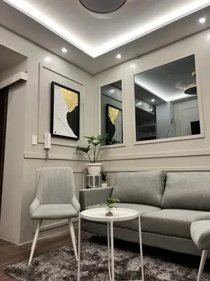 a living room with a couch and two chairs and a table at AM Condotel at Air Residences in Manila