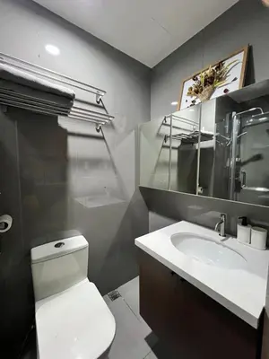 a bathroom with a white toilet and a sink at AM Condotel at Air Residences in Manila