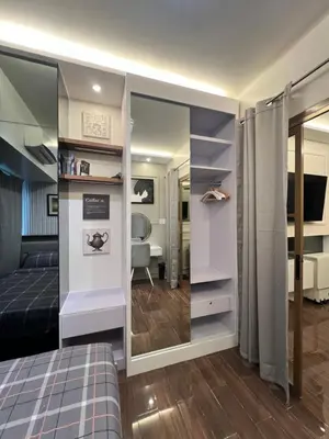 a bedroom with a bed and a mirror at AM Condotel at Air Residences in Manila