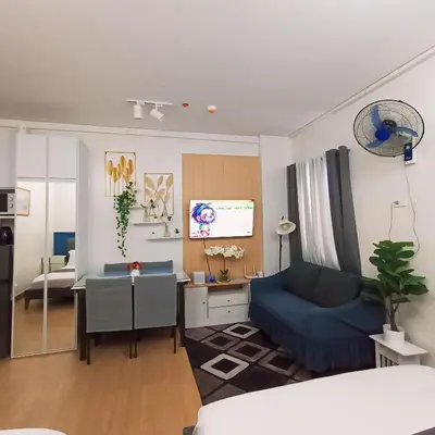 a living room with a blue couch and a table at Anne's Place at Hope Residences - SMDC Condo Beside SM Trece in Trece Martires