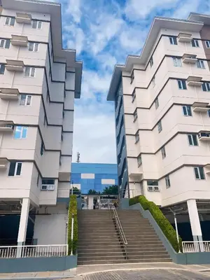 a large white building with stairs in front of it at Anne's Place at Hope Residences - SMDC Condo Beside SM Trece in Trece Martires