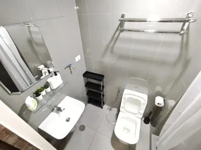 a bathroom with a sink and a toilet and a mirror at Air Residences-The House of Five 2Queen Bed in Manila