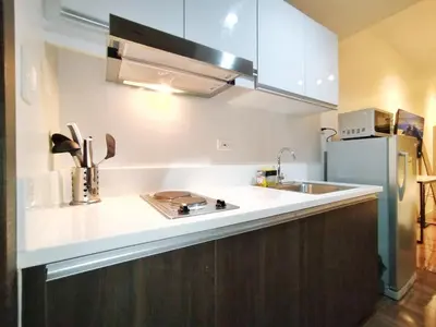 a kitchen with a sink and a refrigerator at Air Residences-The House of Five 2Queen Bed in Manila