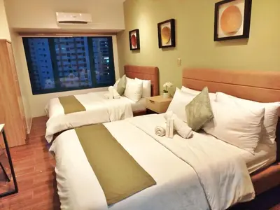 a hotel room with two beds and a window at Air Residences-The House of Five 2Queen Bed in Manila