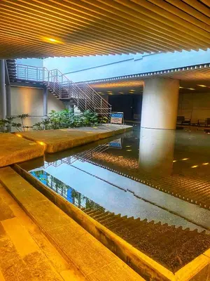 a building with a pond in the middle of a building at Air Residences-The House of Five 2Queen Bed in Manila