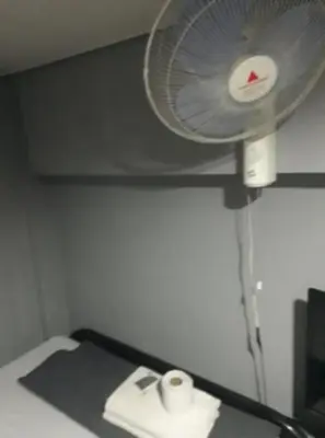 a room with a fan and toilet paper on a bed at Slouch Hat Hotel and Restaurant in Manila