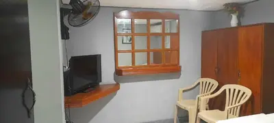 a room with two chairs and a television and a window at Slouch Hat Hotel and Restaurant in Manila