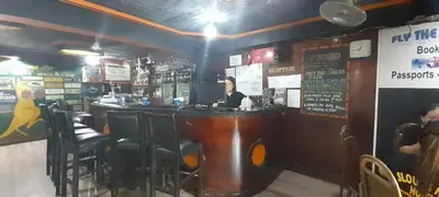 a man sitting at a bar in a restaurant at Slouch Hat Hotel and Restaurant in Manila