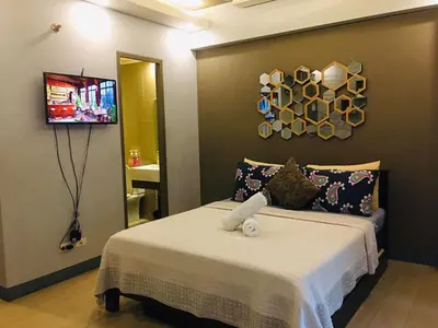 a bedroom with a bed with a towel on it at Two Palm Tree Condotel in Manila