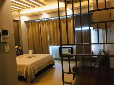 a bedroom with a bed in a room at Two Palm Tree Condotel in Manila