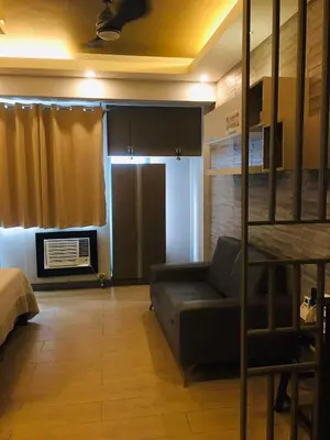 a living room with a couch and a bunk bed at Two Palm Tree Condotel in Manila