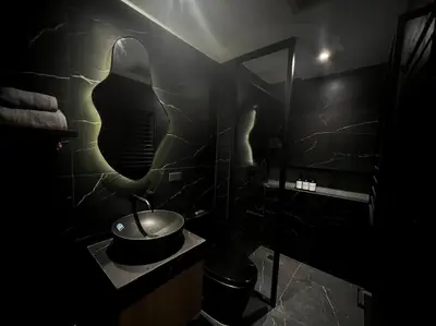 a black bathroom with a sink and a mirror at Modern Nordic 1 Bedroom Condo near Eastwood, Quezon City in Manila