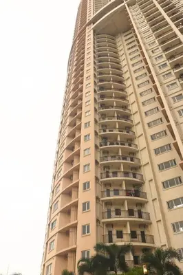 a tall building with palm trees in front of it at Modern Nordic 1 Bedroom Condo near Eastwood, Quezon City in Manila
