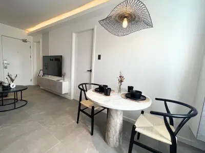 a living room with a table and chairs and a television at Modern Nordic 1 Bedroom Condo near Eastwood, Quezon City in Manila
