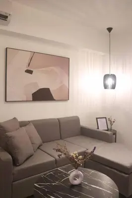 a living room with a couch and a table at Modern Nordic 1 Bedroom Condo near Eastwood, Quezon City in Manila