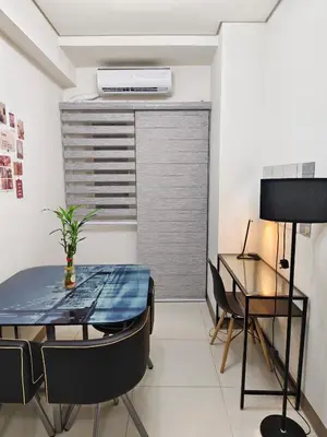 a dining room with a table and chairs and a window at Cozy Easy Escape in Manila