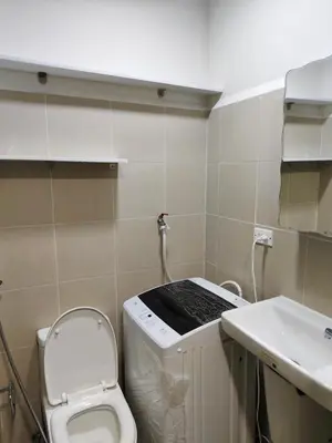 a small bathroom with a toilet and a sink at Cozy Easy Escape in Manila