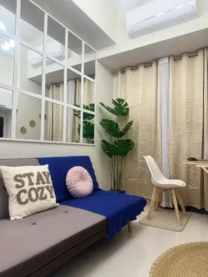 a living room with a blue couch and a plant at Staycation At Shore by LAYANDY in Manila