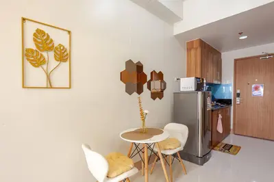 a kitchen with a small table and a refrigerator at Staycation At Shore by LAYANDY in Manila