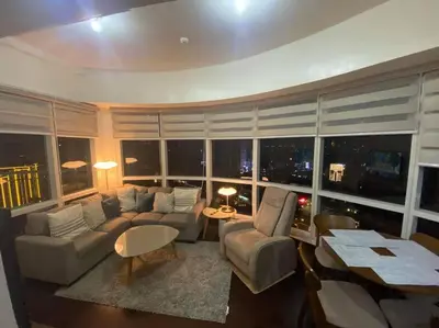 a living room with a couch and a large window at 1BR Premium condo - Twin Oaks Pl PANORAMIC VIEW in Manila