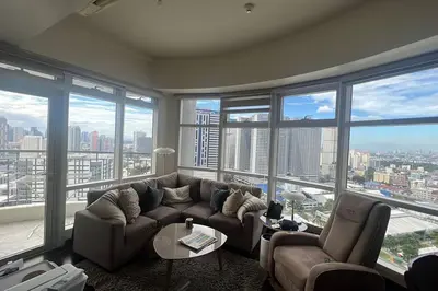 a living room with a couch and chairs and large windows at 1BR Premium condo - Twin Oaks Pl PANORAMIC VIEW in Manila