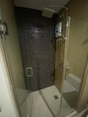 a shower with a glass door in a bathroom at 1BR Premium condo - Twin Oaks Pl PANORAMIC VIEW in Manila