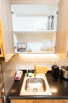 a kitchen with a sink and a counter top at Hotel-Like Staycation1 MOA Pasay in Manila