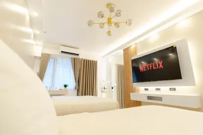 a hotel room with two beds and a flat screen tv at Hotel-Like Staycation1 MOA Pasay in Manila