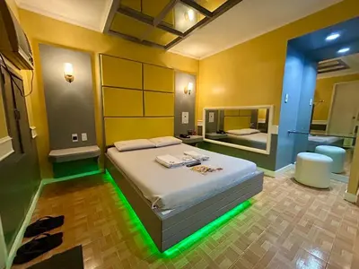 a bedroom with a bed with a green light on it at Town and Country Reposo in Manila