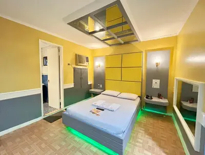 a bedroom with a bed in a room with yellow walls at Town and Country Reposo in Manila